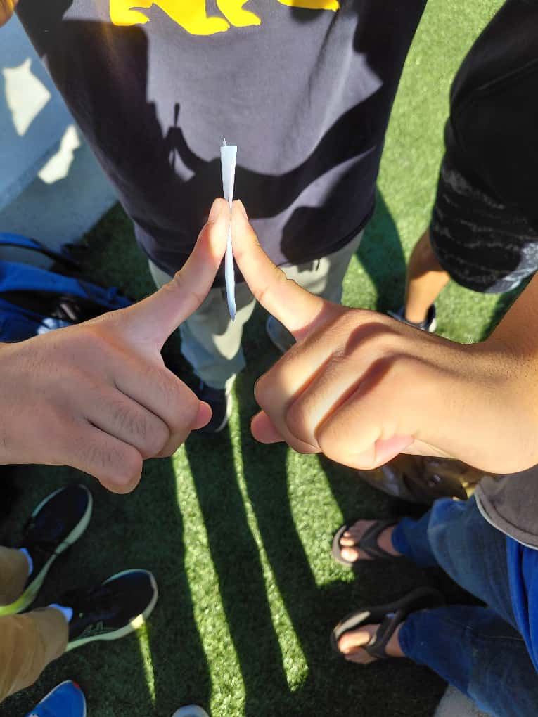 A student holding a paper dart.