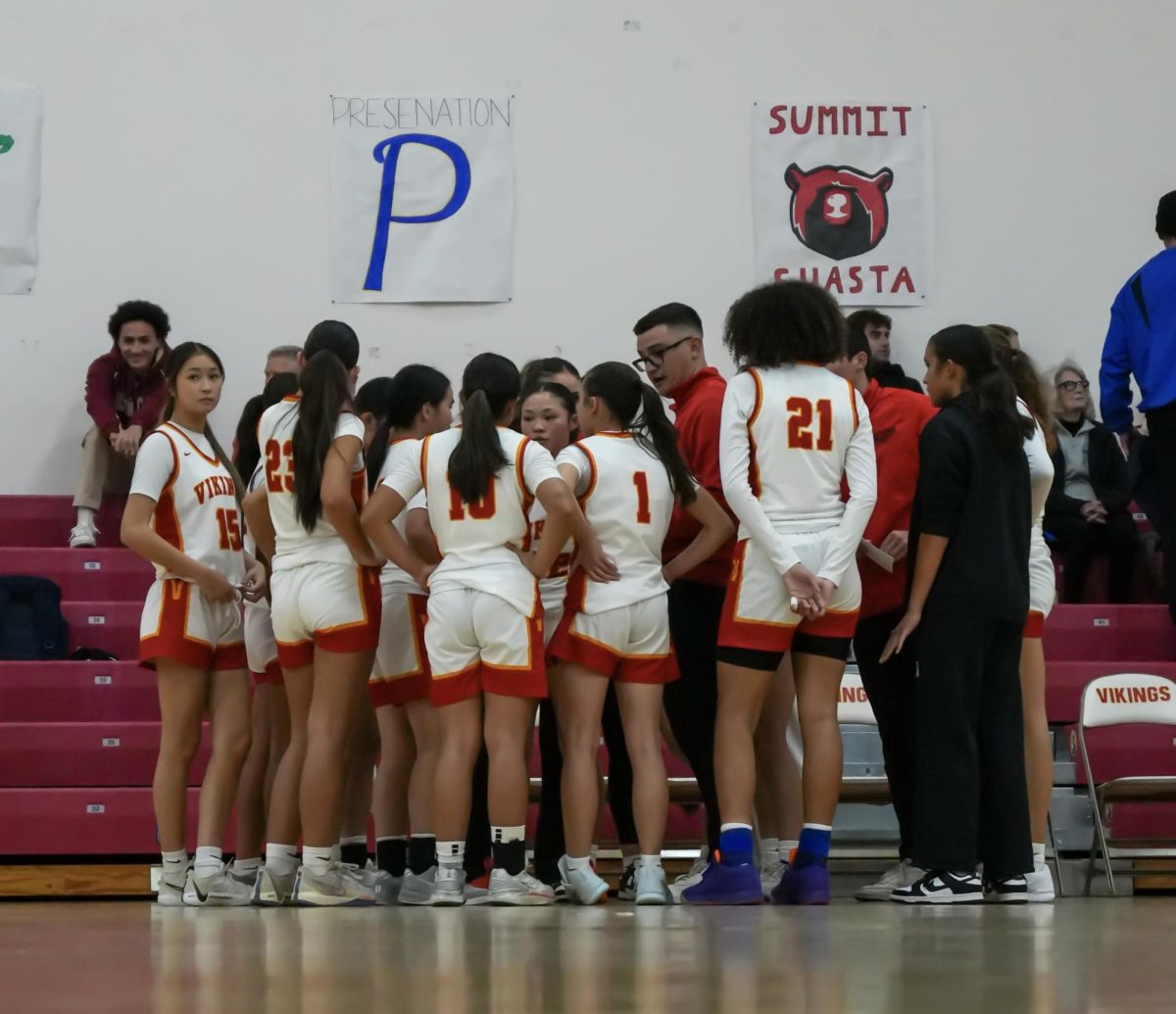 Girls basketball players in a huddle during a team timeout
