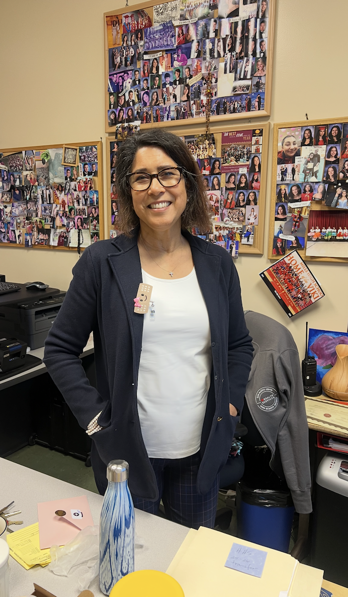 Lori Durham seen standing and smiling for photo inside her office. 