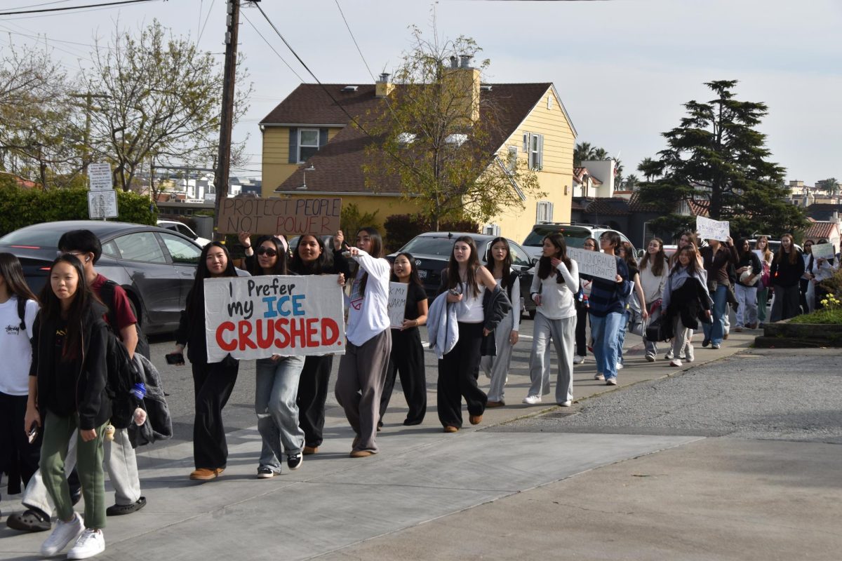 Mills student protesters purposefully walk down the streets of Millbrae, exercising their right to demonstrate.