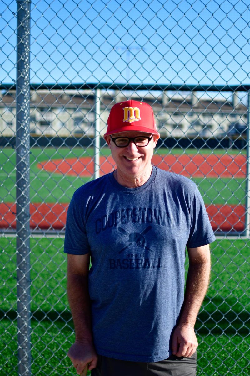 Coach Jeremy Cohen outside baseball field getting his picture taken 