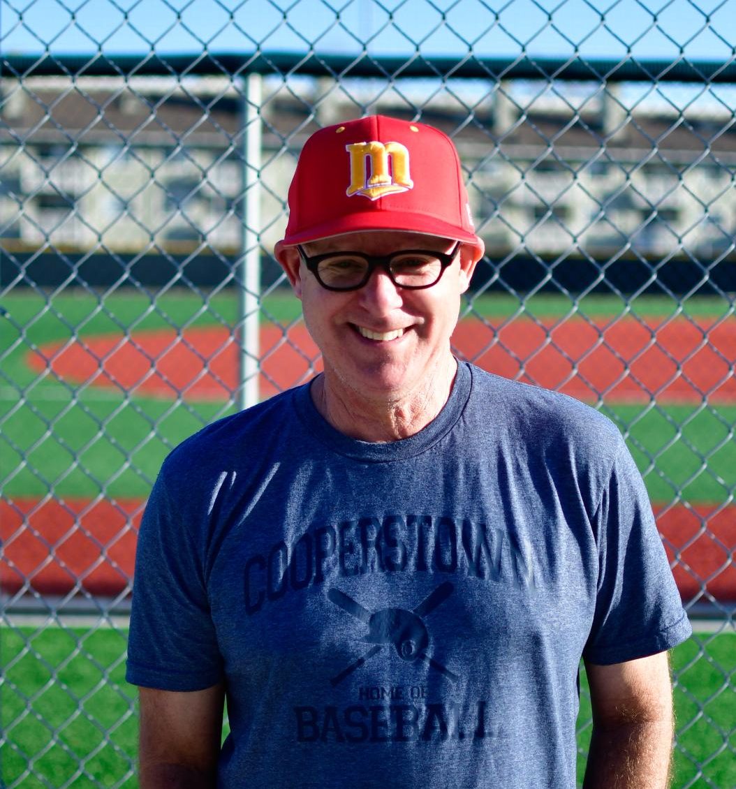 Coach Jeremy Cohen outside baseball field getting his picture taken 