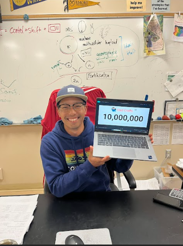 Steven Wang proudly holds up his computer displaying his 10 million subscribers on his YouTube channel: Dad Crafts. 